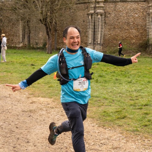 Un homme mature court avec les bras &eacute;cart&eacute;s pour c&eacute;l&eacute;brer son arriv&eacute;e